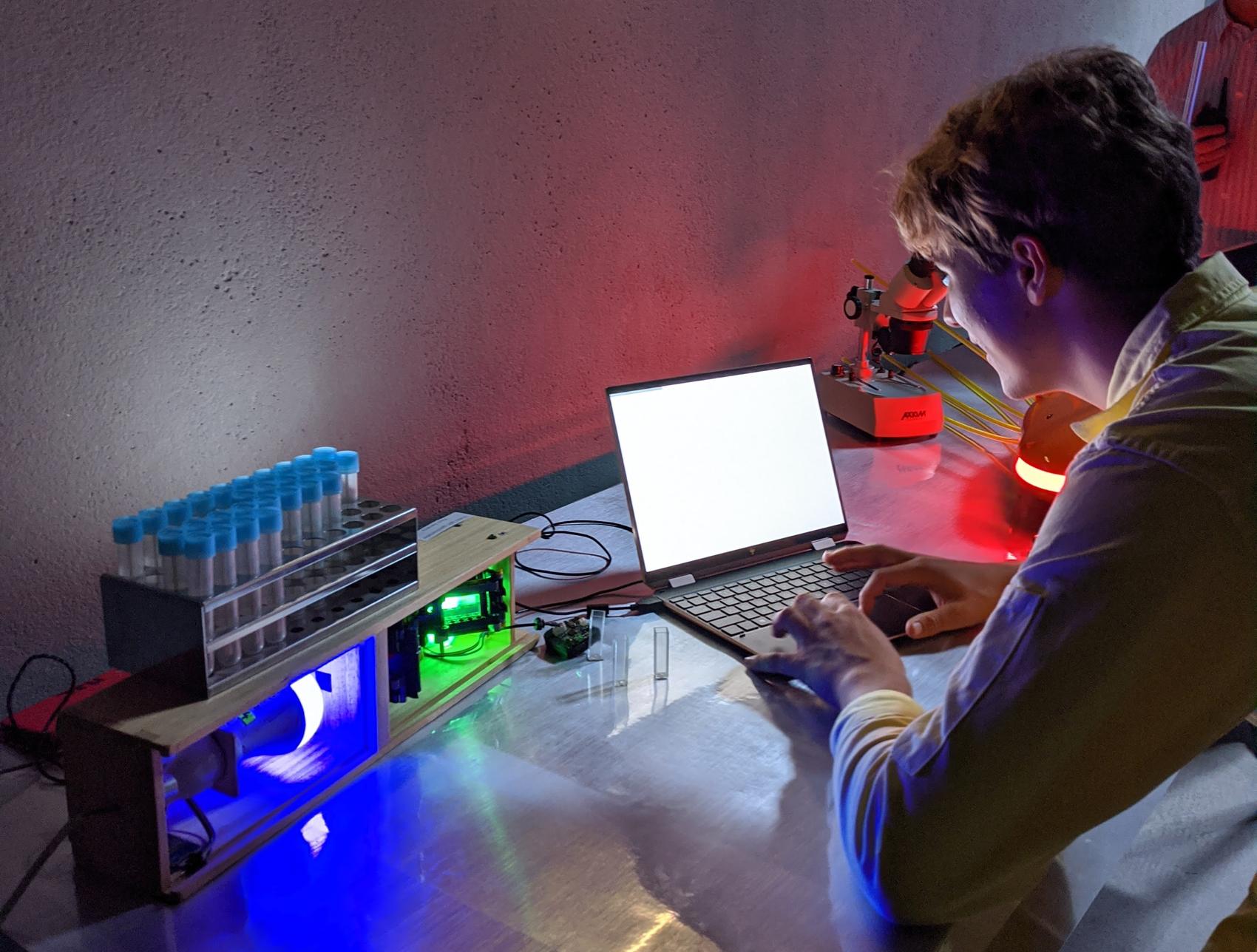 Home-built spectrometer made of plywood and LEDs, with racks of sample tubes
